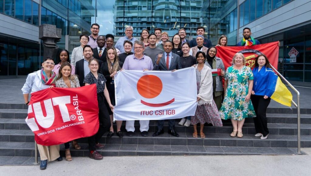 A group of international trade unionists in gathered together in Vienna, Austria, holding various unions banners.