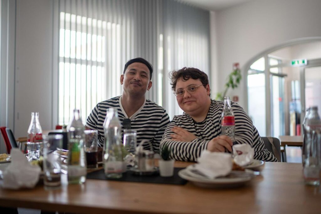 Two people seated enjoying lunch wearing matching shirts.