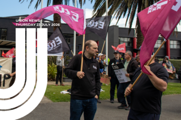 E tū members rally with flags and placards outside a building. Text overlay reads: "Union News, Thursday 23 July 2026."