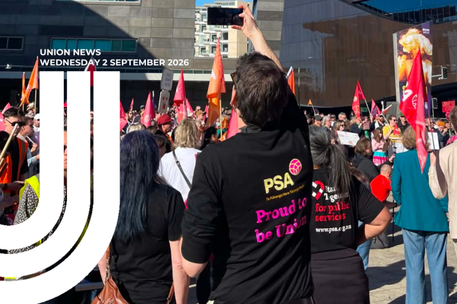 Union News graphic featuring a crowd of union members at an outdoor rally, holding flags and placards. In the foreground, people wear black PSA T-shirts reading 'Proud to be Union' and 'Stand together for public services'. One person holds a phone overhead to film the crowd.