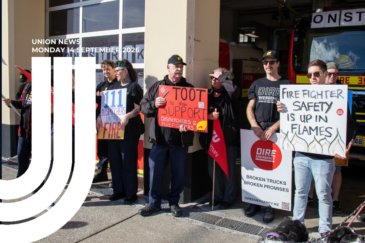 Graphic for Union News: Monday 14 September 2026. Colour photo of firefighters and supporters picketing outside a fire station, and a fire engine in the bay behind them. People in black NZPFU and union gear hold placards. Red NZCTU Te Kauae Kaimahi flags are among the group. White curved lines overlay the left side of the image.