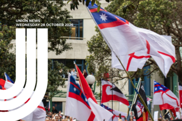 Graphic for Union News: Wednesday 28 October 2026. Colour photo of He Whakaputanga flags – white with a red cross, a blue canton and four white stars – flying above a crowd outside Parliament, with Tino Rangatiratanga flags among them. Trees and a building are in the background. White curved lines overlay the left side of the image.